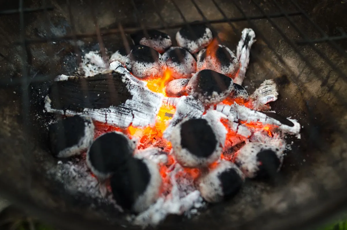 Noch glühende Holzkohle mit grauer Asche