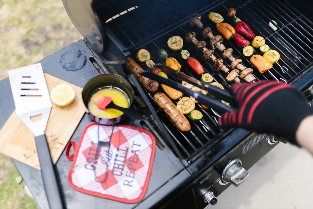 Grillen mit schützenden Handschuhen