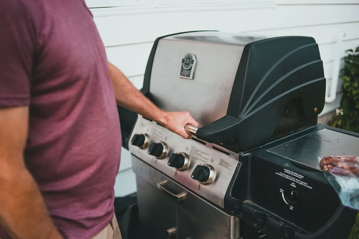 Opening the lid of an outdoor grill