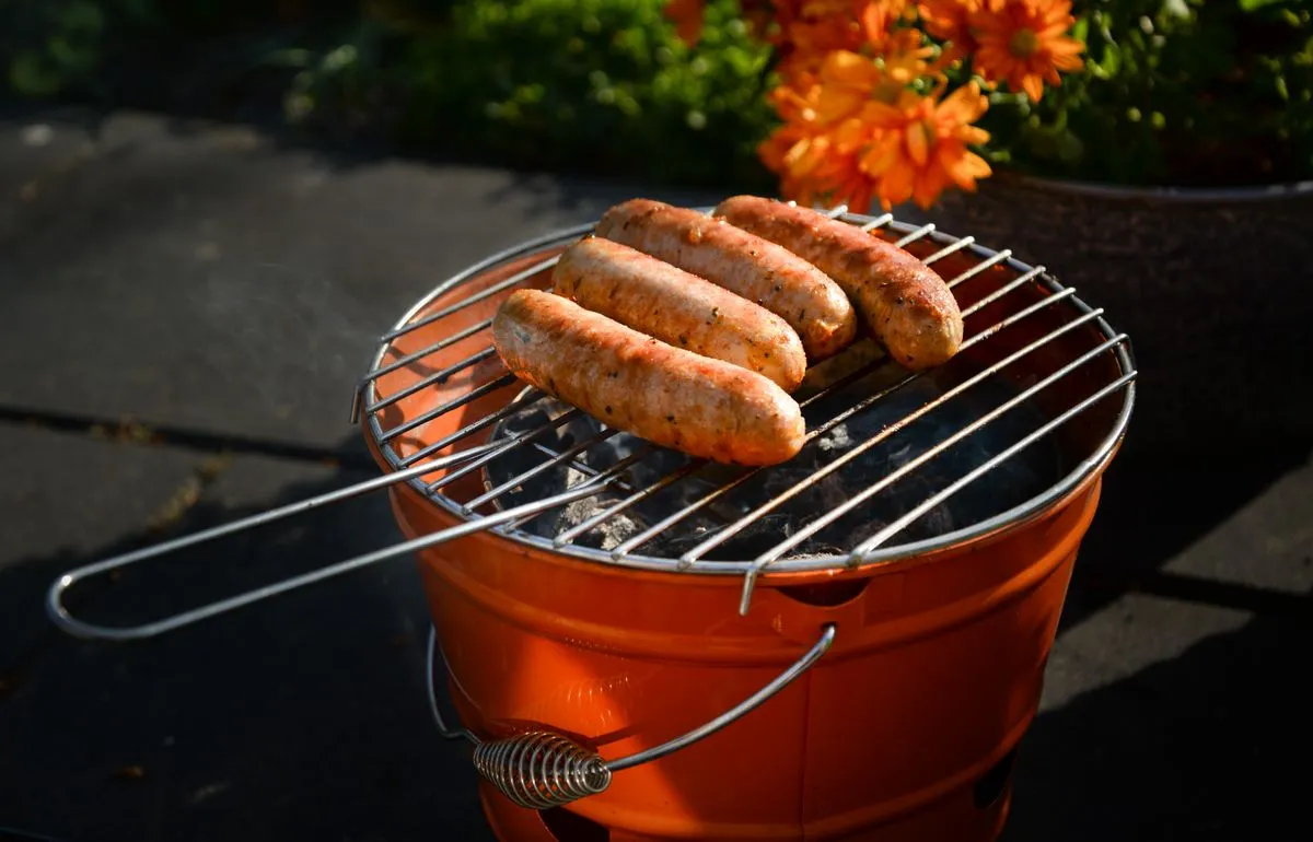 Kleiner Holzkohlegrill mit Würsten