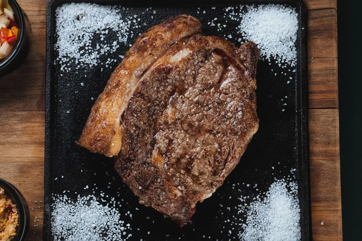 Gegrilltes Ribeye auf einem dunklen Schneidebrett