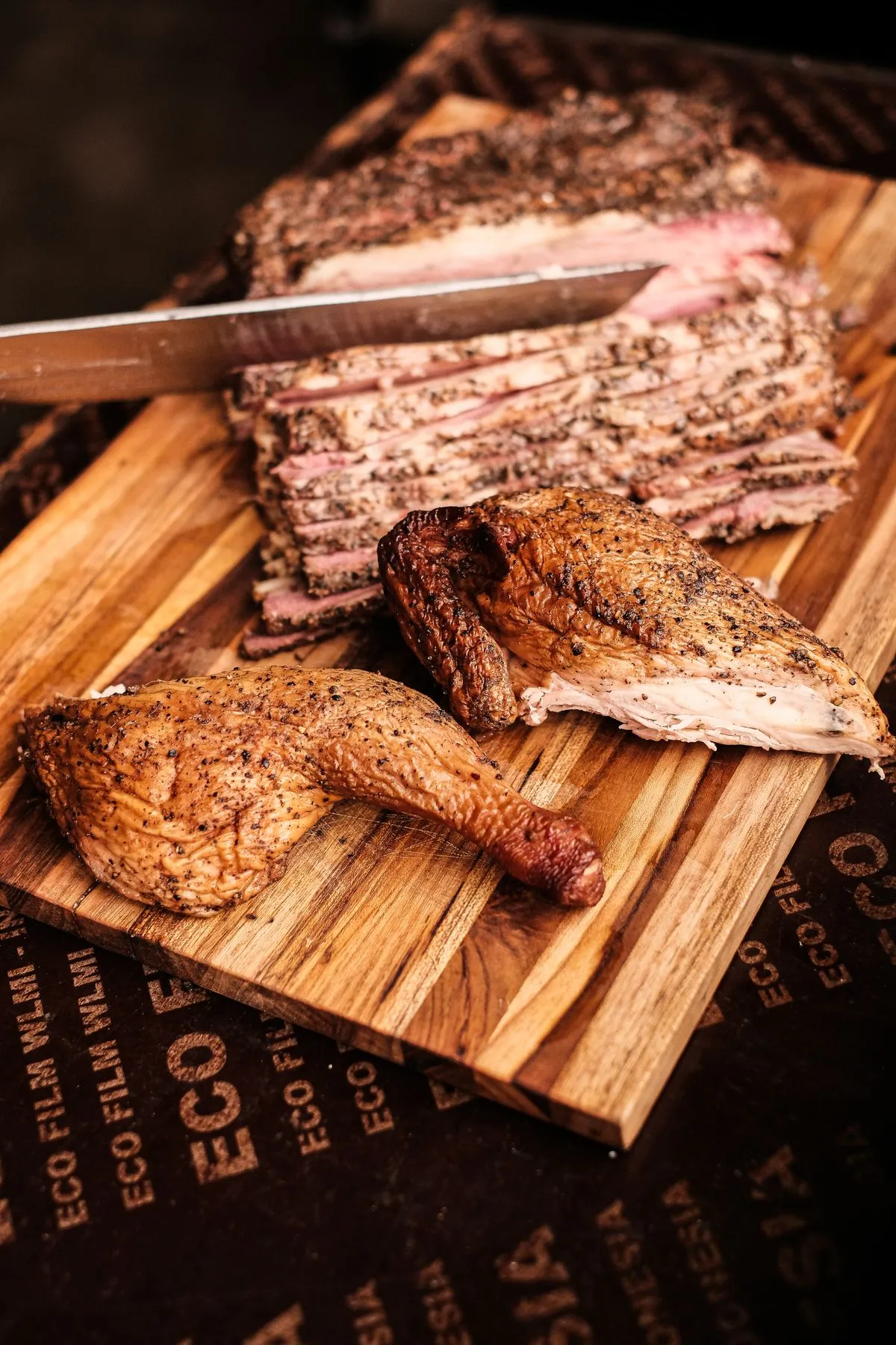 Sliced cooked brisket and chicken on a board