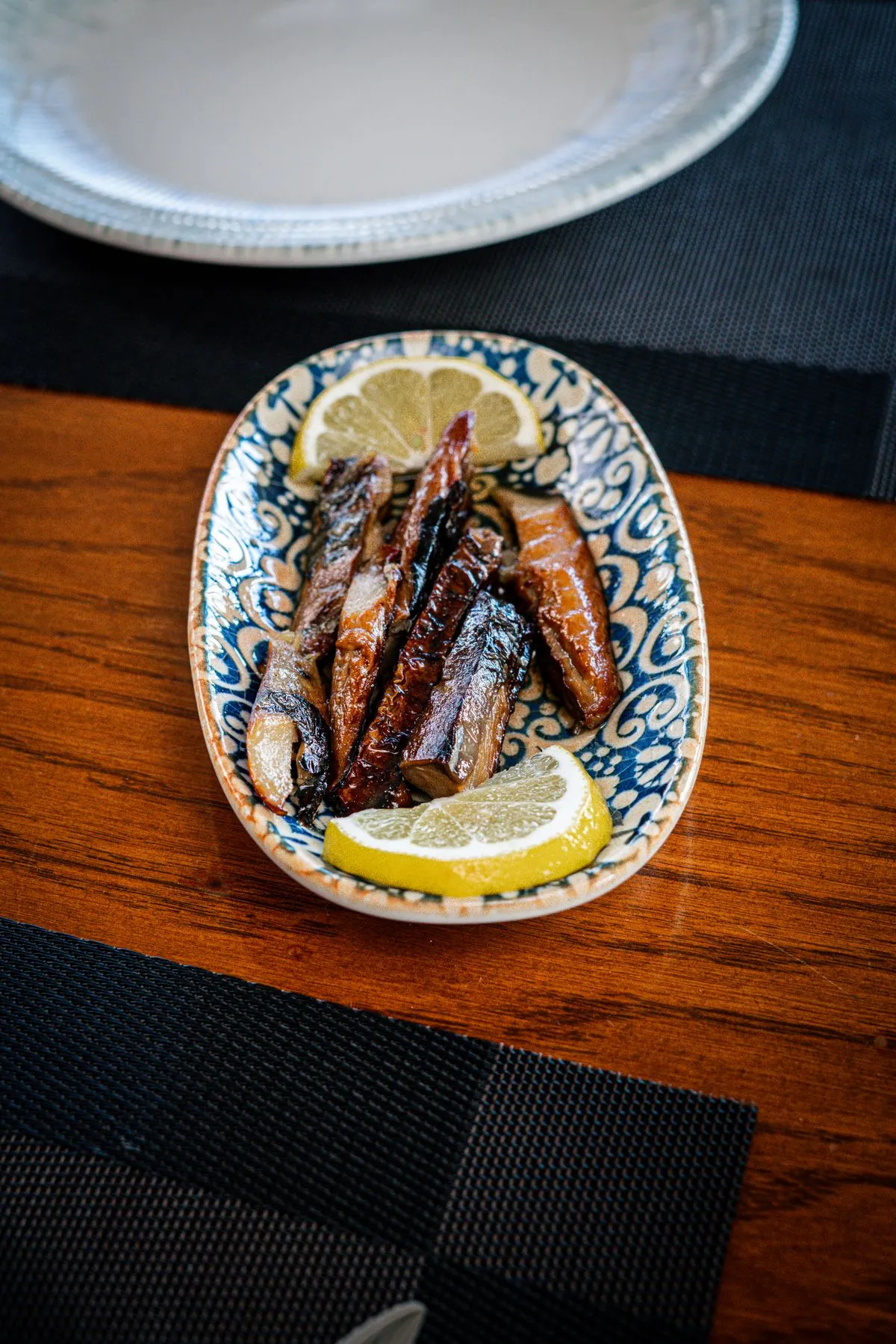 Sardinen mit Zitrone auf einem Keramikteller