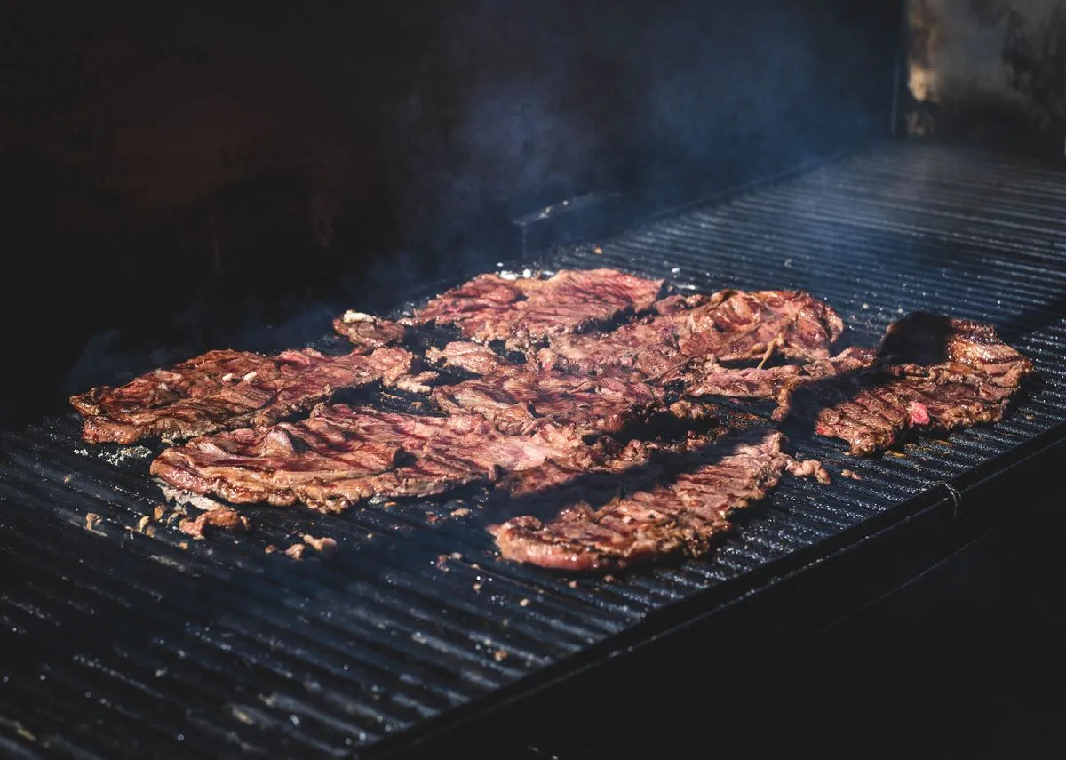 Steak cooking on a grill grate